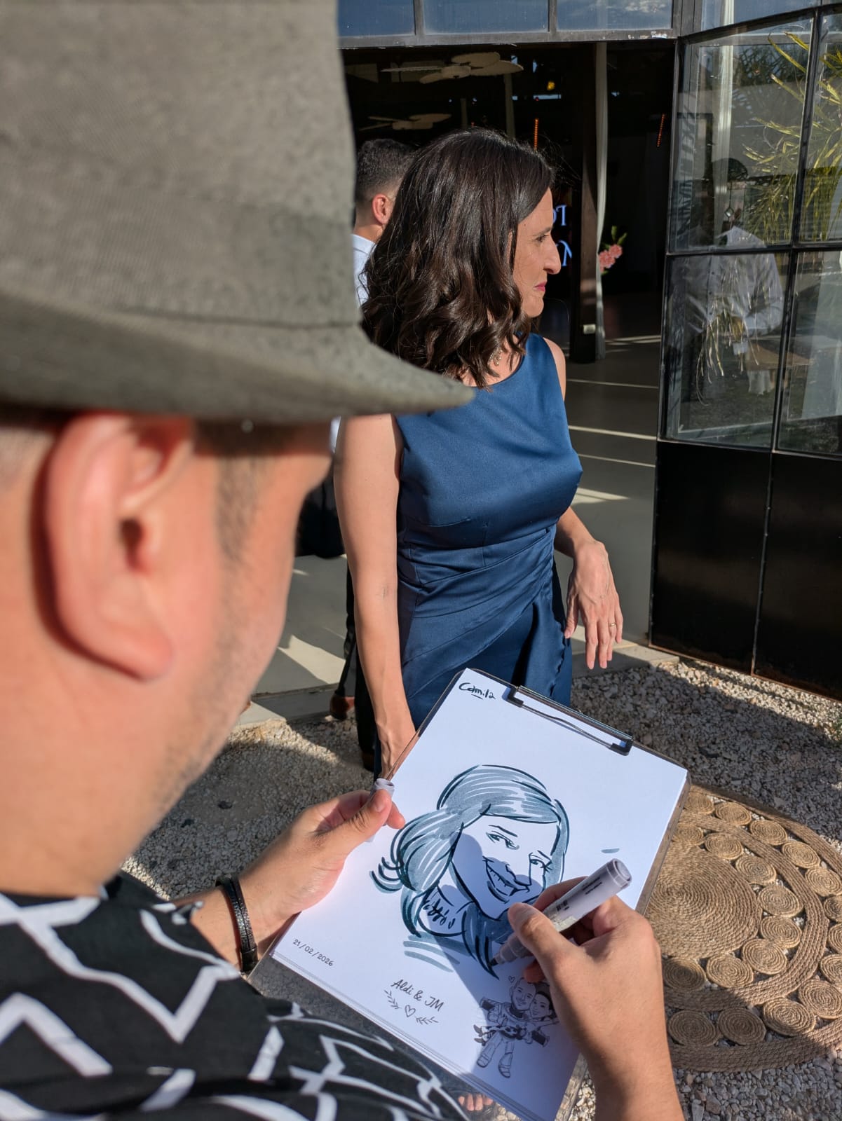 Artista realizando la caricatura de una invitada durante el evento