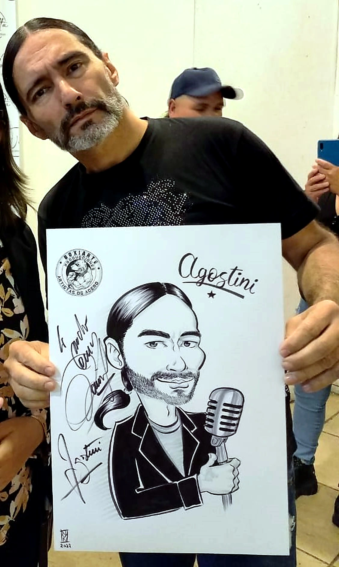 Daniel Agostini mostrando su caricatura personalizada
