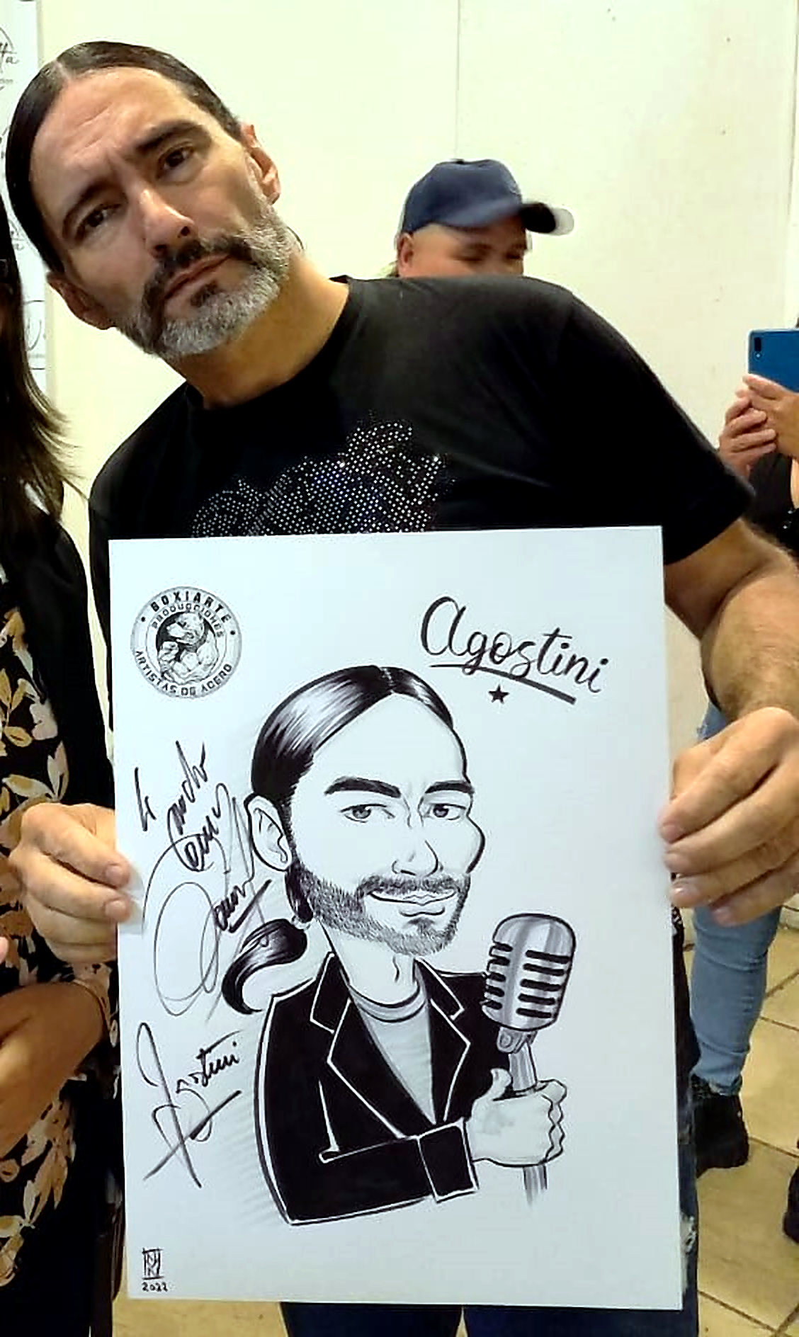 Daniel Agostini mostrando su caricatura personalizada